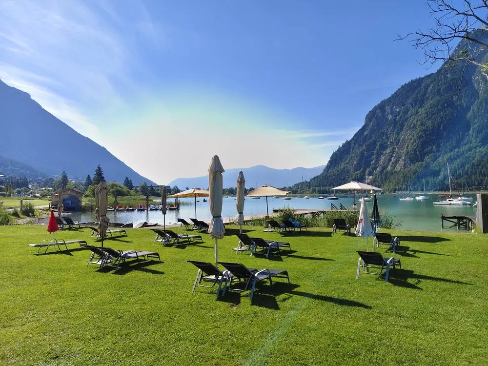 Liegestühle und Sonnenschirme am Morgen auf der Seewiese Buchau am Achensee