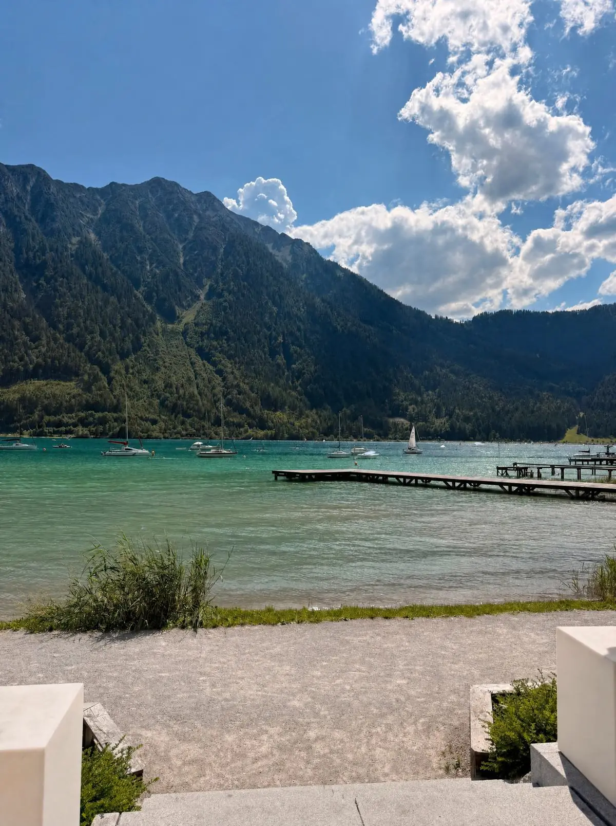 Windsurf-Spot Achensee: türkises Wasser mit Steg und steilen Bergflanken